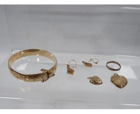 A bag of yellow plated metal jewellery to include a gold plated metal core bangle, lockets etc