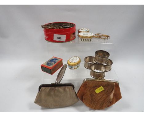 A set of four hallmarked silver napkin rings approx. combined weight 60.6g together with a small tin of collectables to inclu