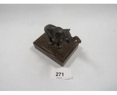 A small bronze figure of a baby elephant with a raised trunk on a marble base