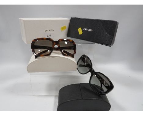 Two pairs of Prada sunglasses in original boxes