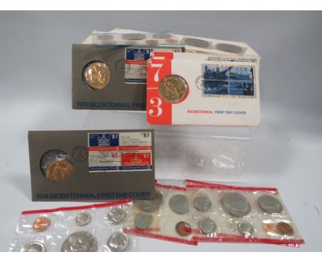 A collection of vintage US coin sets and medallions