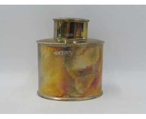 A silver oval tea caddy of plain form, Birmingham 1911, by Alexander Clark Company Ltd.