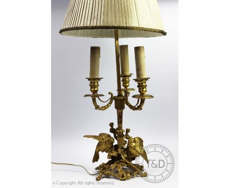 A late Victorian gilt metal table lamp, modelled with two birds, fruit and foliage, with adjustable shade, 57cm high (size in