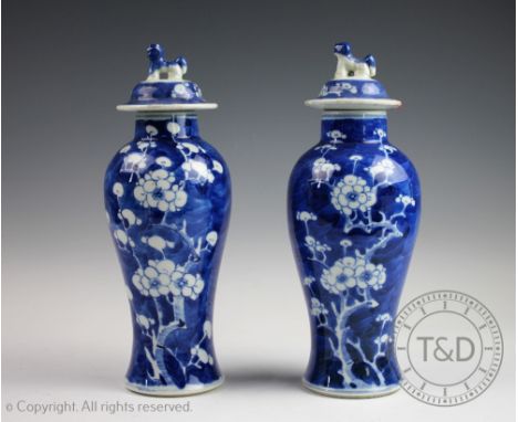 A pair of early 20th century Chinese porcelain blue and white prunus vases and covers, of baluster shape, double concentric b