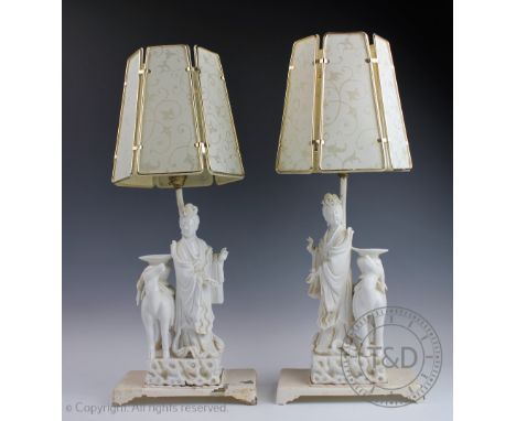 A pair of Chinese blanc de chine glazed lamp bases, modelled as Guanyin standing beside a deer with vessel upon its back, lat