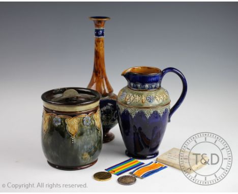 Three pieces of Royal Doulton Art Nouveau stoneware, to include; a pitcher 6824 20cm high, a tobacco jar 8846 15cm high and a