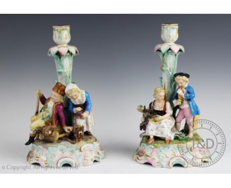 A near pair of Helena Wolfsohn porcelain candlesticks, each emblamatic of the seasons winter and summer, decorated in polychr