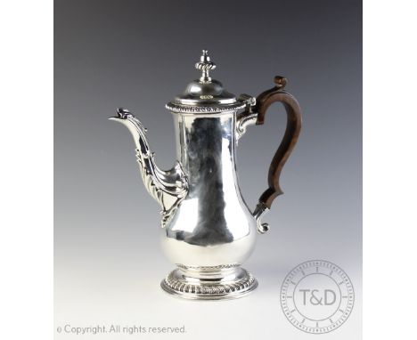 A George III silver coffee pot, London 1765,  of plain baluster form with acanthus moulded spout below a hinged cover with ga