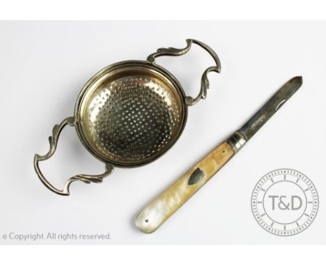 A George V silver strainer, Sheffield 1914, 13cm, with a silver and mother of pearl folding fruit knife, Sheffield 1932 (2)  