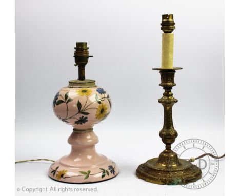 An enamel table lamp, decorated with flowers against a pink ground, 20.5cm high, with a brass candlestick lamp (2)   CONDITIO