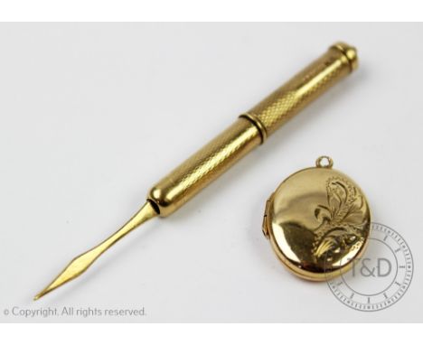 A 9ct yellow gold retractable toothpick Birmingham 1977, with engine turned decoration, along with a 9ct yellow gold oval loc