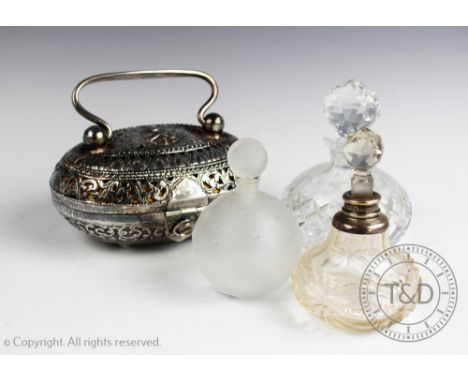 A Burmese silver casket, the oval box and cover profusely decorated with pierced floral garlands, with swivel handle and upon