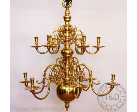 An 18th century style Dutch brass chandelier, with two tiers of six scroll sconce arms and a turned centre with large ball te