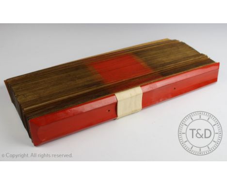 A Buddhist palm manuscript, 20th century, the red lacquered covers enclosing multiple palm leaves with script, gilt and red e