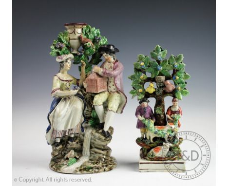 Two Staffordshire pearlware figural groups, early 19th century, each modelled as figures beside a tree with birds, animals an