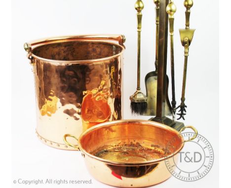 A collection of assorted copper and brass wares to include a copper log bucket with swing handle and ring detail 30cm high, a