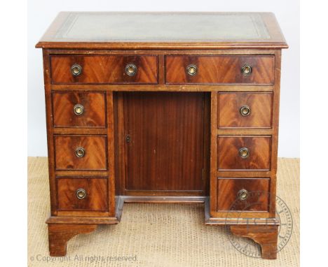 A George III style mahogany knee hole desk, with an arrangement of eight drawers, on bracket feet, 78cm H x 80cm W x 50cm D