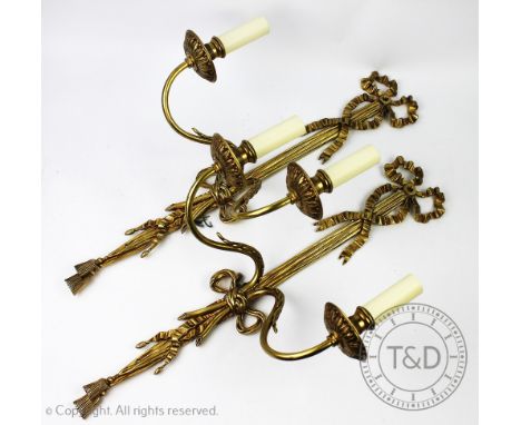 A pair of Regency style twin branch gilt wall sconces, each with tied bow and tassel detail and acanthus leaf sconces, 61cm l