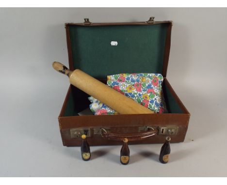 A Vintage Suitcase Containing Wooden Rolling Pin, Miniature Guinness Bottles and Vintage Tabard  