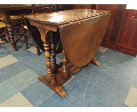 An Oak Drop Leaf Gate Legged Oval Topped Dining Table