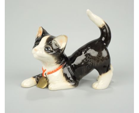 Katze, Feinsteinzeug, Goebel polychrom staffiert, Form-Nr.31 080 13, mit Metallherzanhänger, HxL 12x15cm