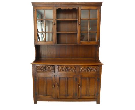 A good reproduction solid oak dresser: the cornice above central shelf space and flanked by two glazed doors enclosing furthe