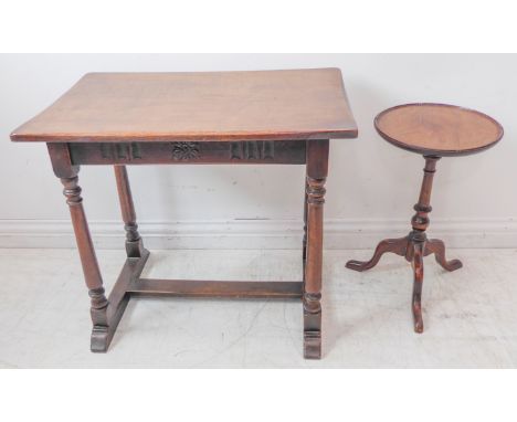 A reproduction style oak occasional table of rectangular form and with carved frieze: gun barrel style legs united by an H-fo