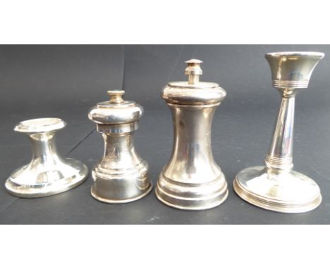 A group of four comprising:an early 20th century hallmarked silver candlestick (weighted) (10cm);a smaller silver table candl