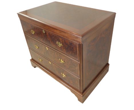 A walnut chest: figured walnut top above three full-width graduated crossbanded drawers and raised on shaped bracket feet in 