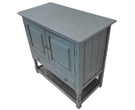 A green-painted shabby-chic-style side cabinet: the overhanging top above two fielded panel doors and single full-width drawe
