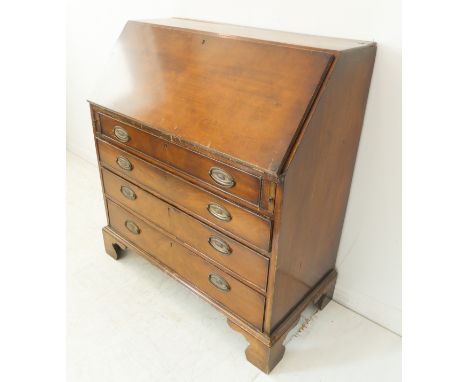 A late 18th century mahogany writing bureau: the angular fall opening to reveal fitted interior of central cupboard door, pig