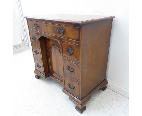 A mid-18th century style (later) mahogany kneehole desk: the flame veneered and crossbanded moulded top above a single full-w