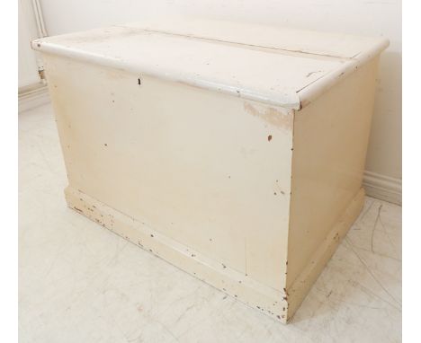 A large white-painted (later) pine trunk: the lid with strap hinges above original lock and escutcheon, raised on plinth base