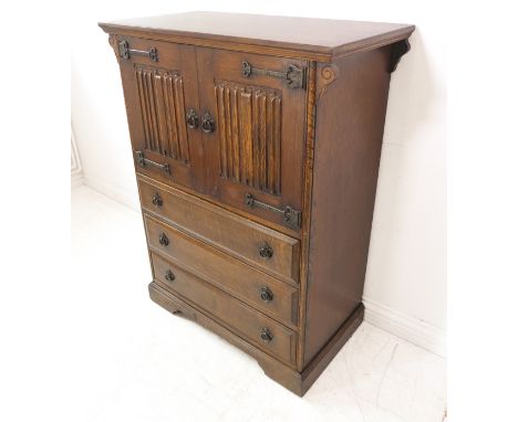 A good reproduction oak side cabinet/chest: the two upper doors with blacksmith-style iron handles and linenfold panels above