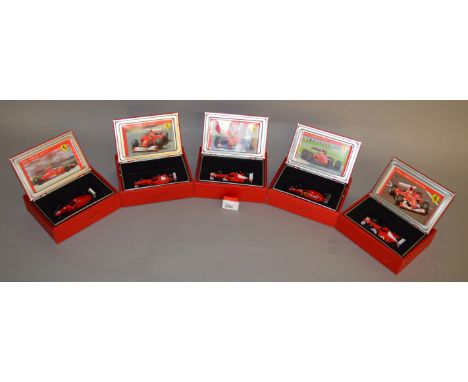 Five Hot Wheels diecast Ferrari models in 1:43 scale including a 1992 F92A, a 1994 F412T1B, a 2000 F1 and a 2002 F2002 togeth