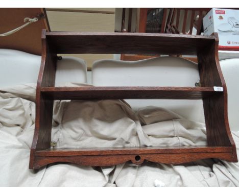 A late 19th/early 20th Century oak wall shelf in the arts and crafts style