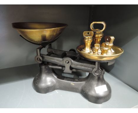 A vintage balance scale set and graduated brass weights