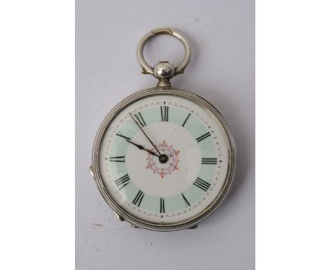 A small silver cased key wind watch with an elaborate case and two tone enamel dial.