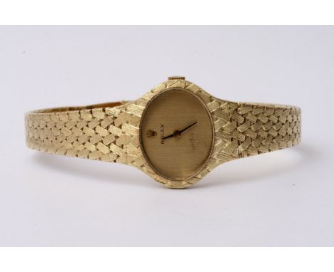 A lady's Rolex watch all 14ct gold with a woven strap and oval dial with the Rolex crown, button wind mechanical Rolex moveme
