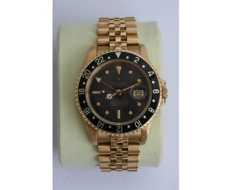 A quality Gents solid 18ct gold Rolex GMT- Master watch, the watch with black dial and black inser enamel outer bezel with ju