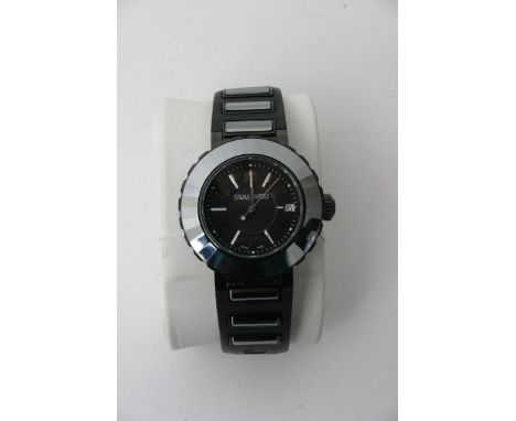 A boxed Swarovski watch black enamel finish stainless steel back, rubber strap, serial number 1049643. Very good condition re