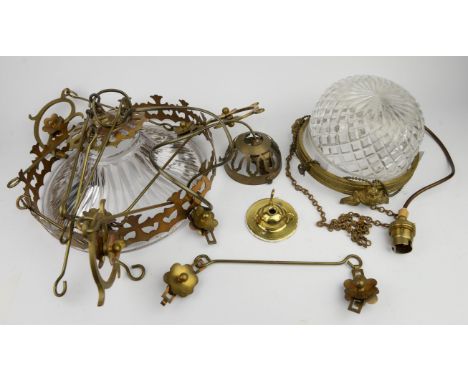 A late 19th century ceiling light of domed cut glass form enclosed by a brass circlet moulded with cherub masks and suspended