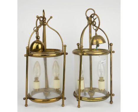 A pair of 20th century gilt brass hall lanterns of cylindrical form, each enclosing a twin light fitment, 40 cm high.  (2)