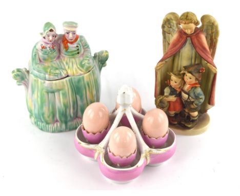 Late 19th century egg server, with four cups and fake eggs, together with a Goebbels figure of an angel and children, an Arth