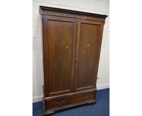 A GEORGIAN MAHOGANY PANELLED DOUBLE DOOR WARDROBE, Heal and Son, London label to interior, carved cornice above a single draw