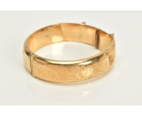 A 9CT GOLD HINGED OVAL BANGLE, half engraved (a.f. this bangle is damaged in several places) hallmarked 9ct gold, Birmingham,