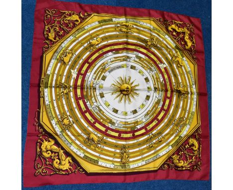 A HERMES SILK SCARF DECORATED WITH SIGNS OF THE ZODIAC, no signature to border, dark red ground with shades of green, mustard