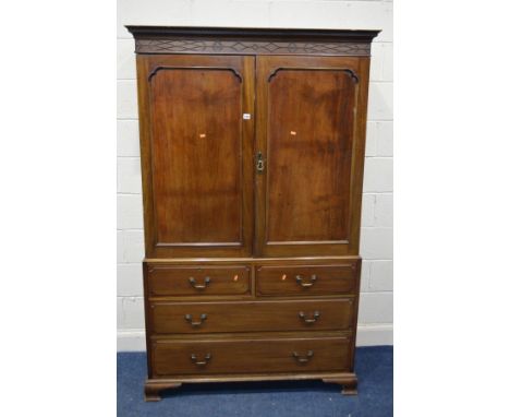 A GEORGIAN MAHOGANY LINEN PRESS, carved cornice, double panelled doors enclosing four linen slides and a base with two short 