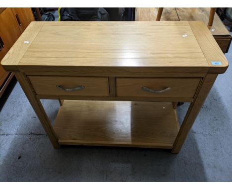 A contemporary lightwood sideboard and matching five drawer tall boy, the sideboard with two frieze drawers, shaped legs unit