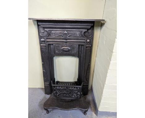 A cast iron fire surround with mantle shelf in the art nouveau style, 97.5 x 71.5 x 5cms, along with a cast iron fire guard, 